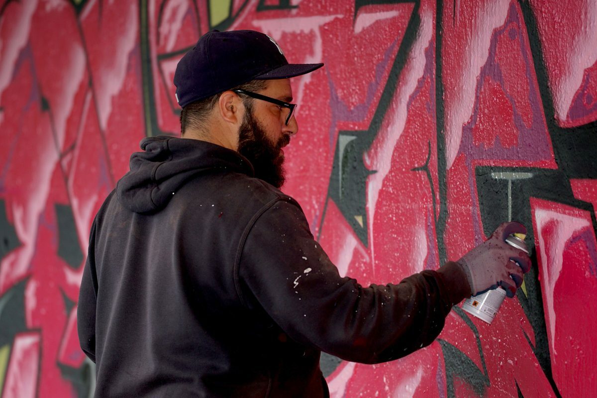 Os desafios da produção artística no Brasil: imagem de uma pessoa fazendo arte em um muro
