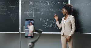 Debate sobre a qualidade do ensino superior a distância no Brasil: imagem de uma professora gravando aulas