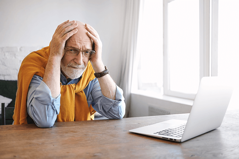 A questão do analfabetismo digital no Brasil: imagem de um senhor com a expressão preocupada em frente ao computador