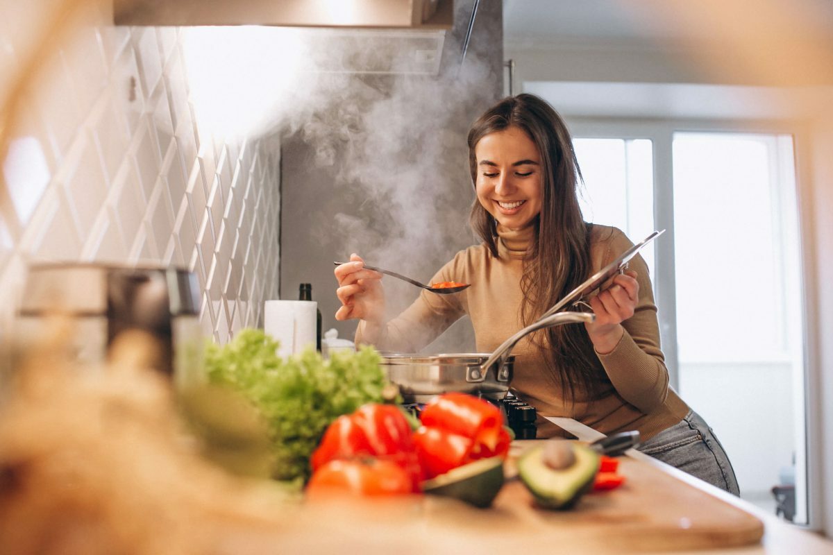 O aumento do vegetarianismo no Brasil: imagem de uma pessoa cozinhando com vegetais