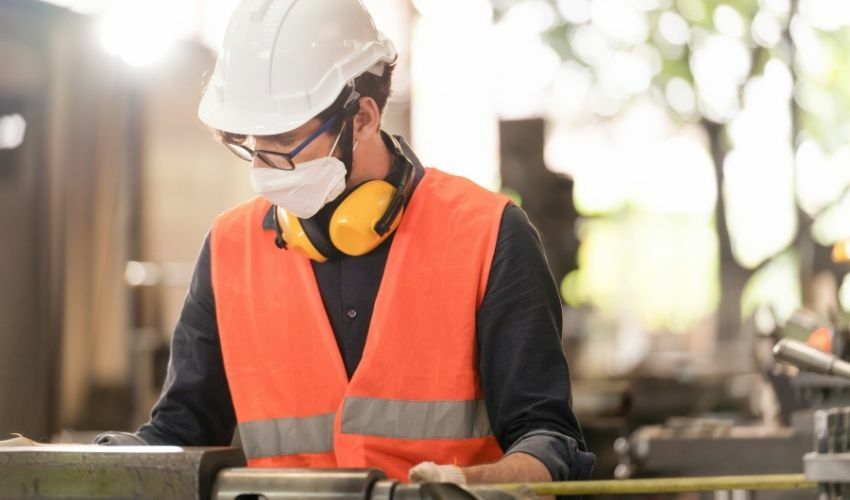 A importância da prevenção aos acidentes de trabalho no Brasil: homem trabalhando em uma fábrica