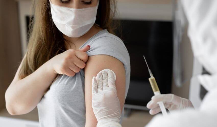 Debate sobre a quebra de patentes de vacinas contra a COVID-19: imagem de uma mulher sendo vacinada